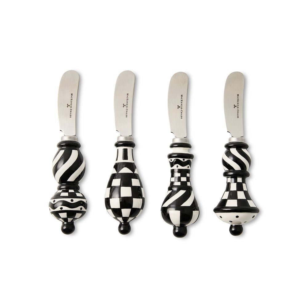 Four decorative knives with black and white patterned handles on a white background