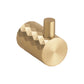 A modern cylindrical wall hook with a faceted geometric pattern on the main body and a brushed metal top loop, shown in a warm gold/brass finish against a plain white background.