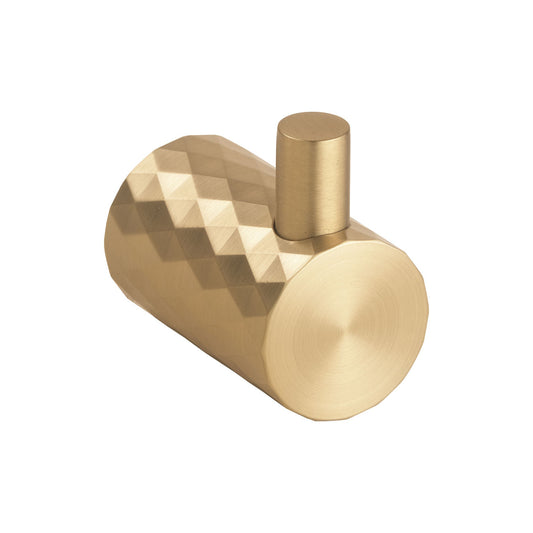 A modern cylindrical wall hook with a faceted geometric pattern on the main body and a brushed metal top loop, shown in a warm gold/brass finish against a plain white background.